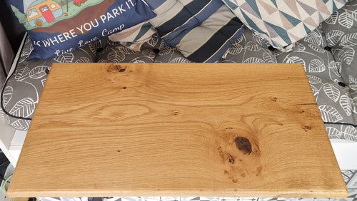 Handcrafted solid oak campervan table showing full surface area and natural wood grain inside a van conversion seating area.