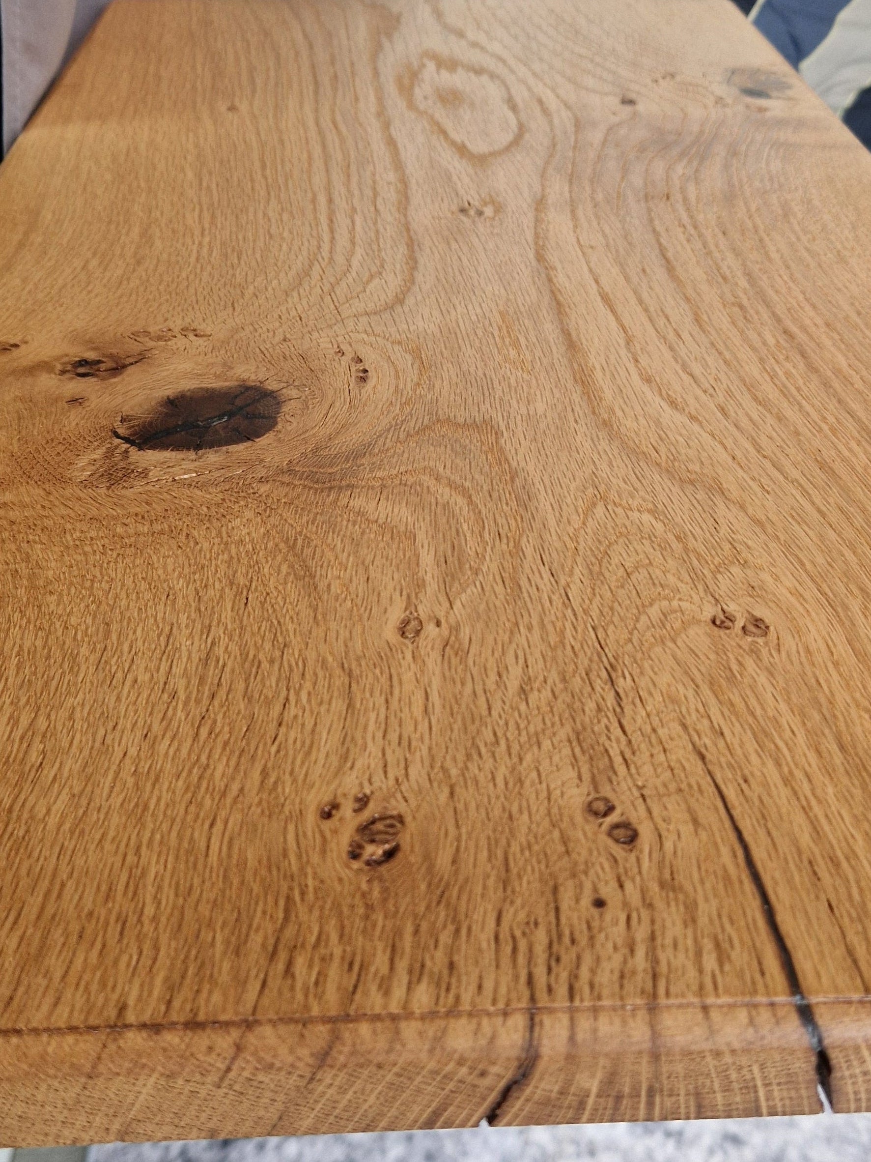 Close-up detail of solid oak campervan table showing natural wood grain patterns and knots with oiled finish.